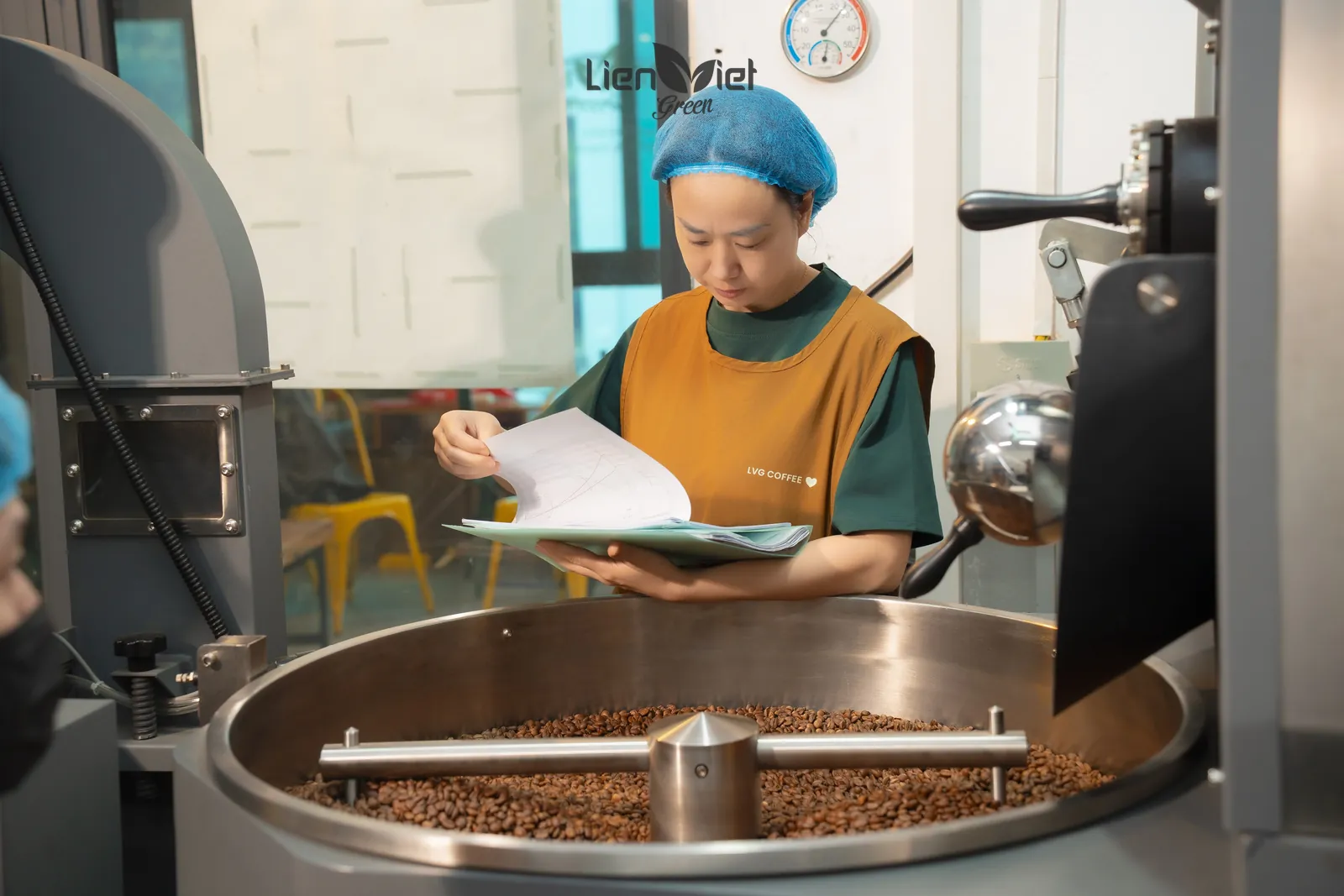 Chị Hương, chủ xưởng và Q Grader, xem hồ sơ rang bên mâm làm nguội tại xưởng
